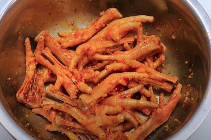 Công đoạn ướp chân gà với muối ớt và gia vị.